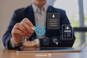 Homem de terno usando tablet para análise e validação de documentos digitais, com ícones de checklist e aprovação, representando consulta e verificação de RPV e precatórios pelo LCbank.