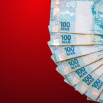 Cédulas de dinheiro brasileiro em formato circular sobre fundo vermelho, representando valores financeiros, pagamento e crédito judicial.